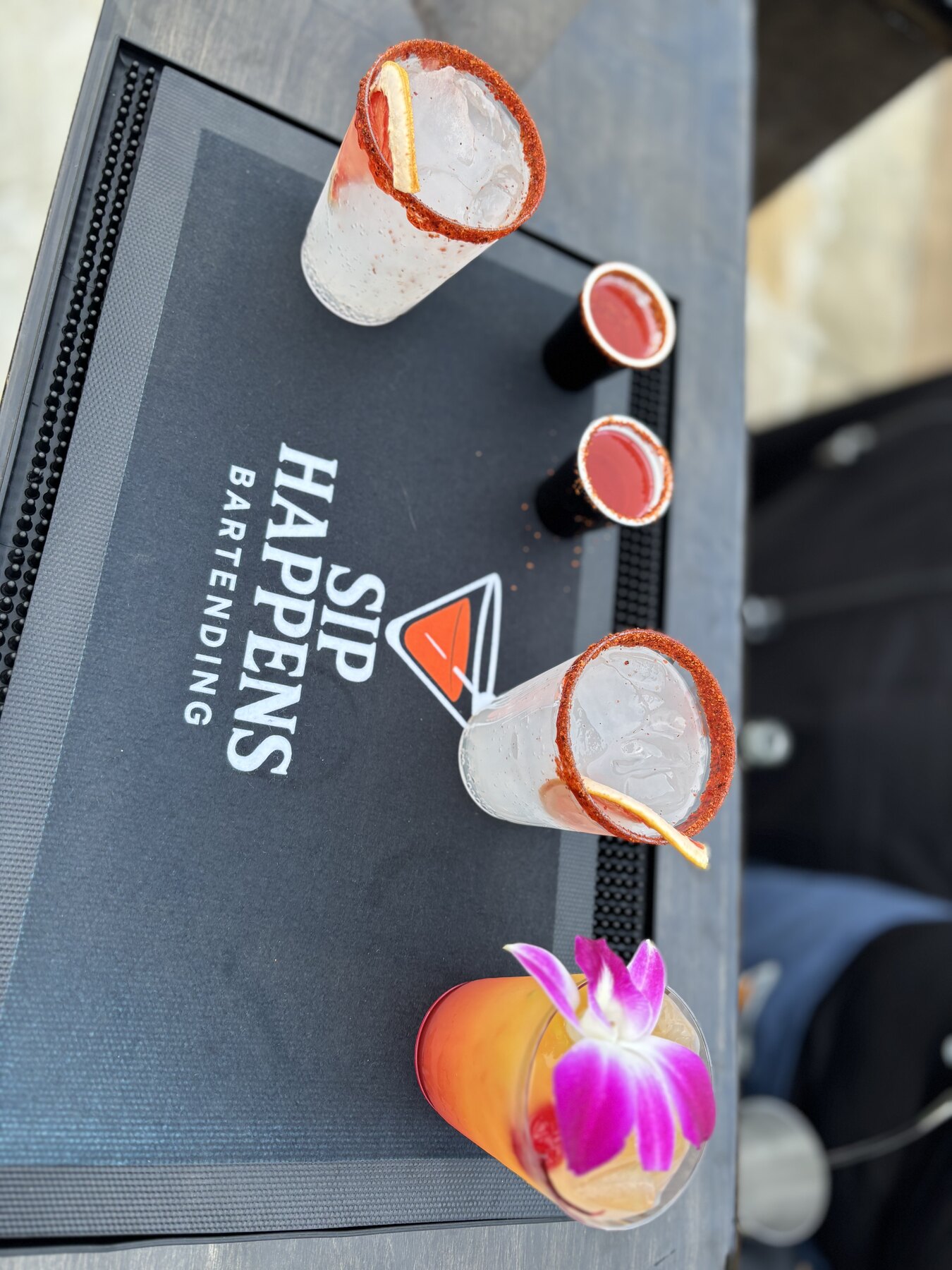 Chamoy-rimmed micheladas and a tequila sunrise on the Sip Happens Bartending bar mat
