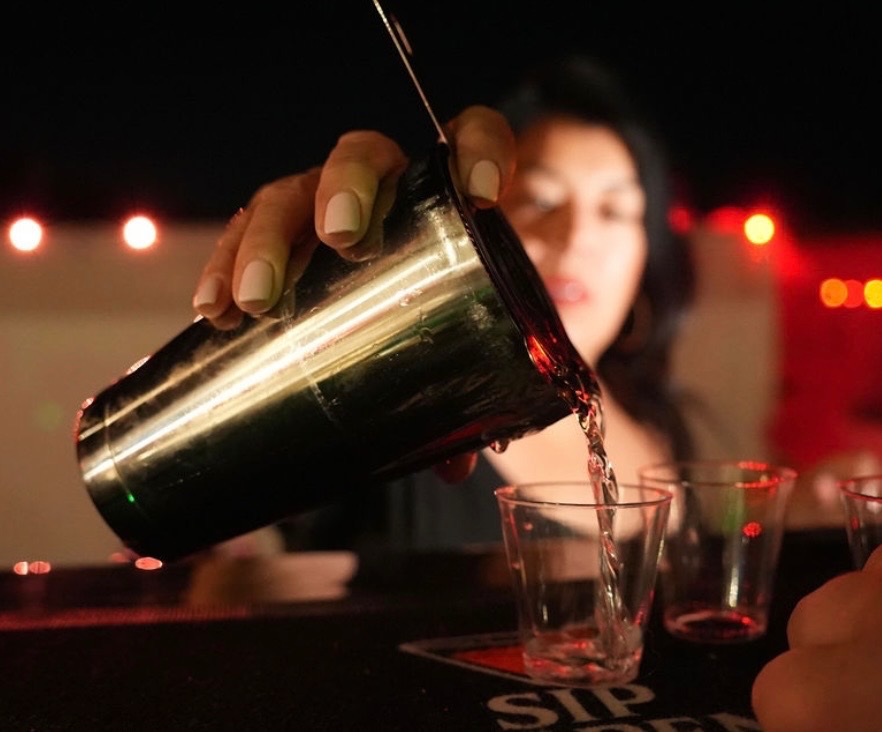 Sip Happens Bartending pouring drinks at a night event